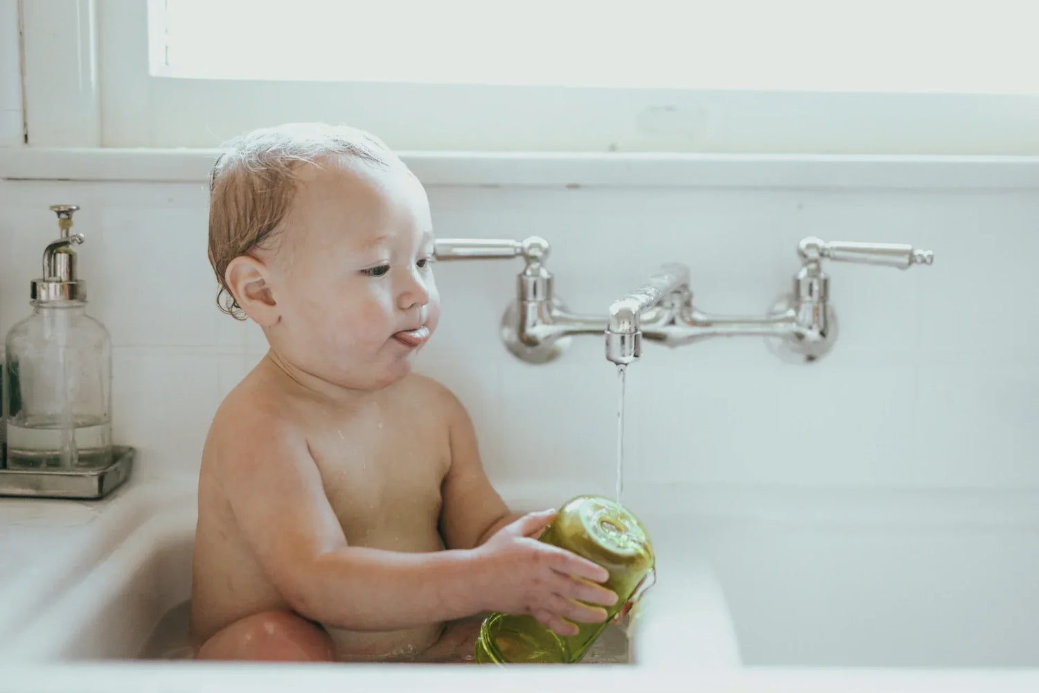 Comment se débarrasser des poux chez bébé, nos conseils ! Photo d'un bébé de 6 mois dans sa baignoire.